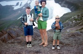 A rare photo of Mom with all three sons.  Your author is on the right.  Note my dutiful older brother holding the purse and bottle.